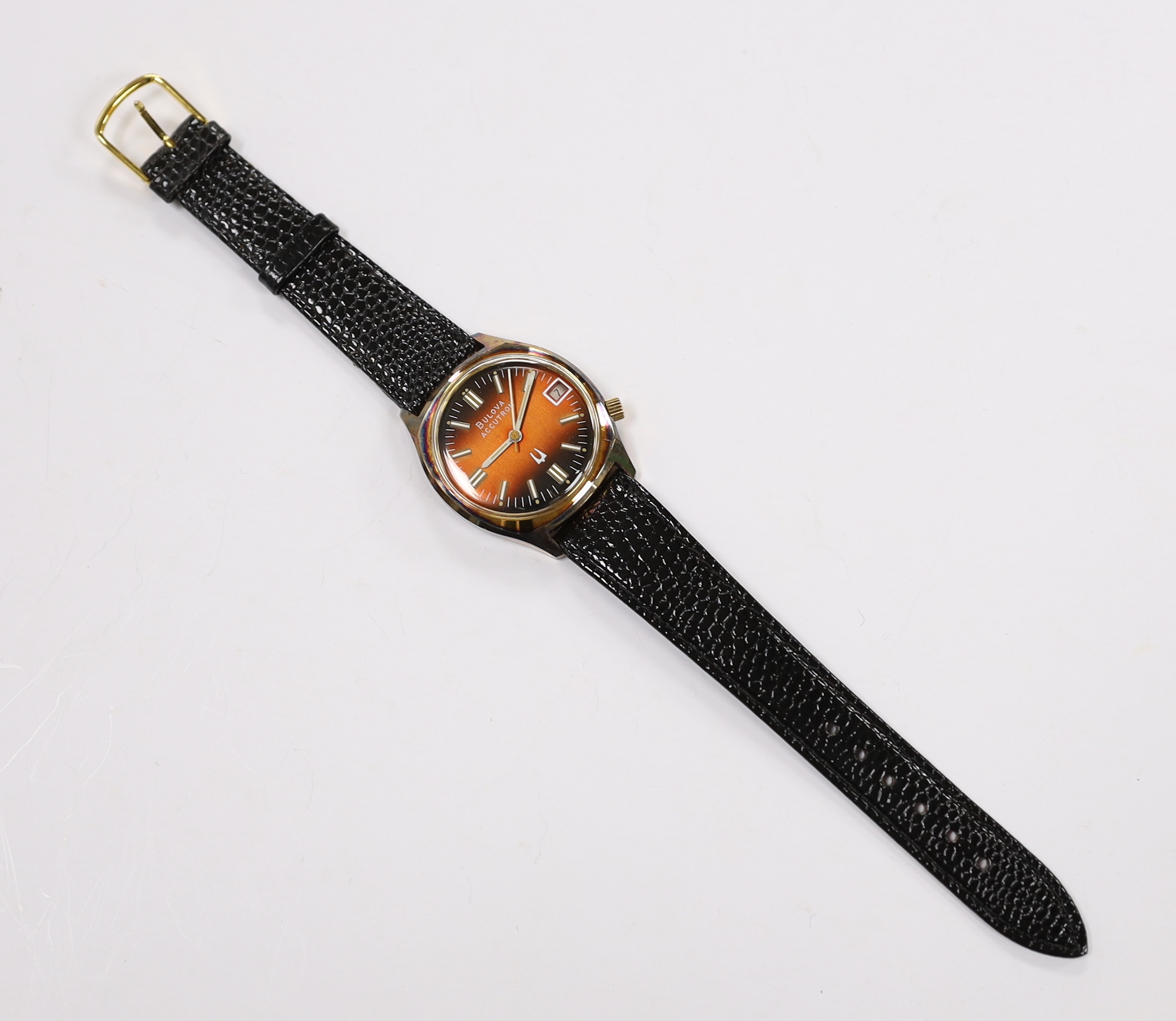 A gentleman's stainless steel and base metal Bulova Accutron wrist watch, with two tone dial, on a leather strap, case diameter 34mm.